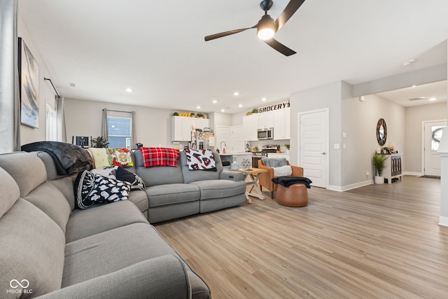 living room featuring ceiling fan and light wood-type flooring