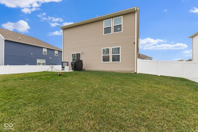 rear view of house featuring a yard