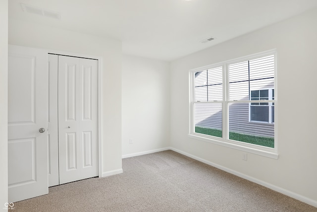 unfurnished bedroom with carpet flooring and a closet