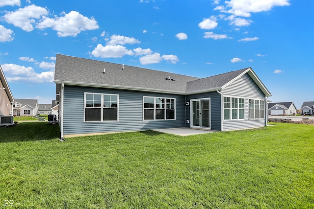 rear view of property with a lawn, central AC unit, and a patio