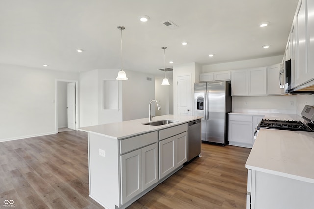 kitchen with light wood-type flooring, sink, a kitchen island with sink, and stainless steel appliances