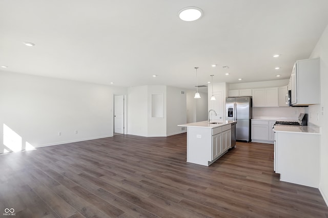 kitchen featuring a kitchen island with sink, dark wood-type flooring, sink, decorative light fixtures, and stainless steel appliances