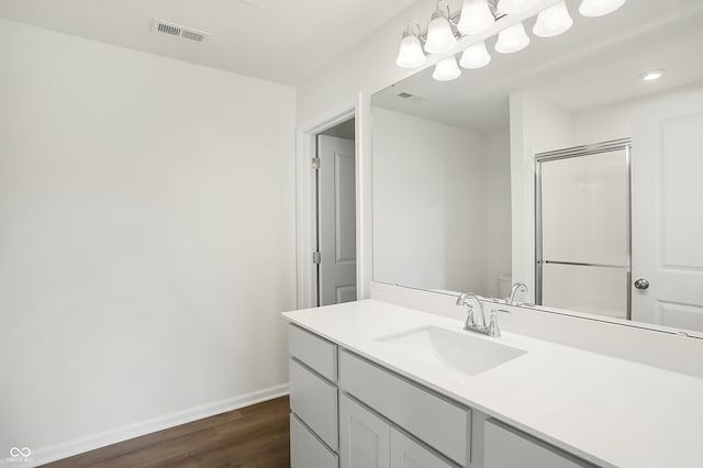 bathroom featuring wood-type flooring, vanity, toilet, and walk in shower