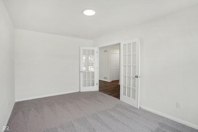 carpeted spare room with french doors