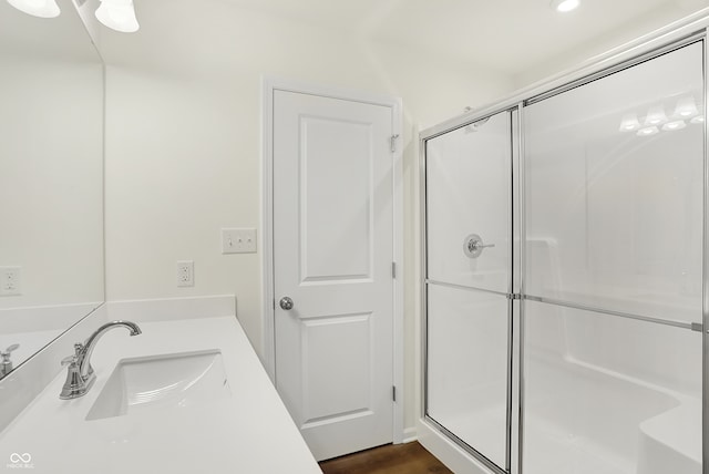 bathroom with a shower with door, vanity, and hardwood / wood-style flooring