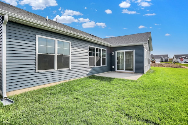 rear view of property featuring a yard and a patio area