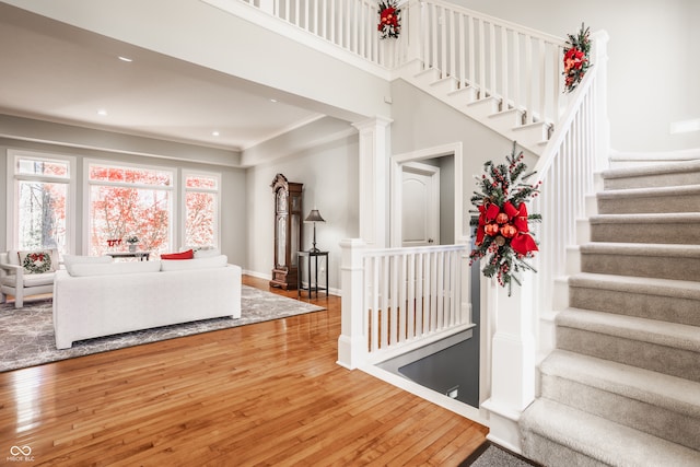 staircase featuring decorative columns and hardwood / wood-style floors