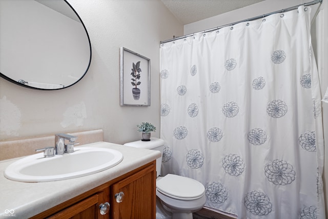 bathroom with vanity, a textured ceiling, toilet, and curtained shower