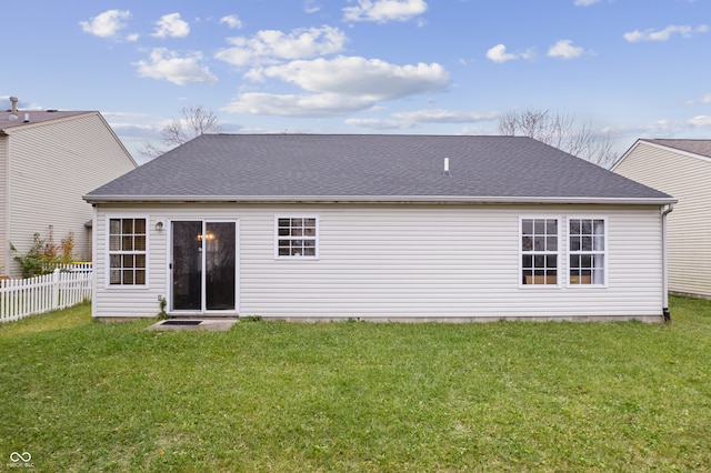 rear view of property featuring a yard