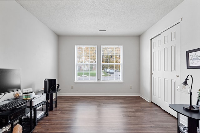 home office featuring a textured ceiling and dark hardwood / wood-style floors