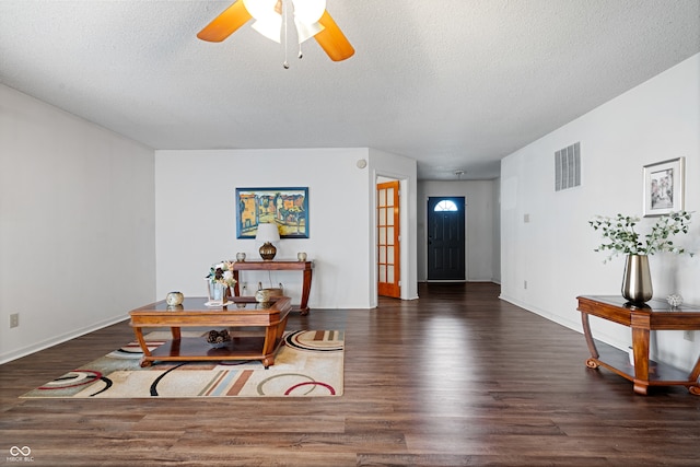 interior space featuring dark hardwood / wood-style floors, ceiling fan, and a textured ceiling