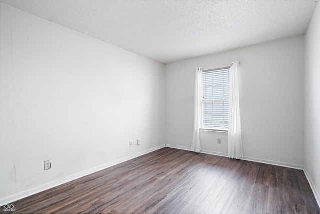 empty room featuring dark hardwood / wood-style flooring and a textured ceiling