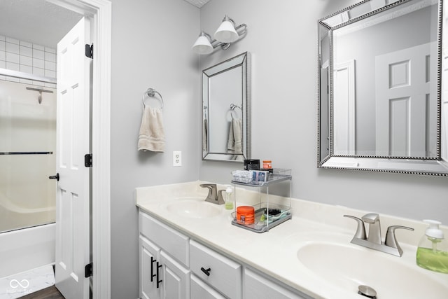 bathroom featuring shower / bath combination with glass door, hardwood / wood-style floors, vanity, and a textured ceiling