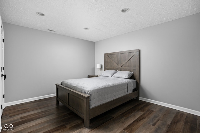 bedroom featuring a textured ceiling and dark wood-type flooring