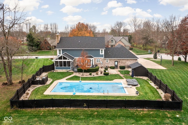 back of house with a yard, a fenced in pool, and a sunroom