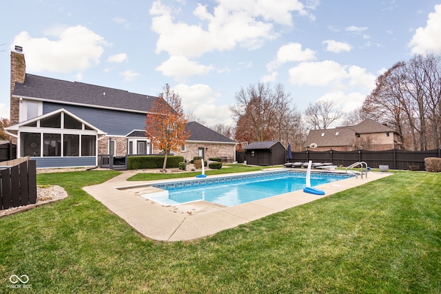 view of swimming pool with a sunroom, a patio area, a storage shed, and a yard