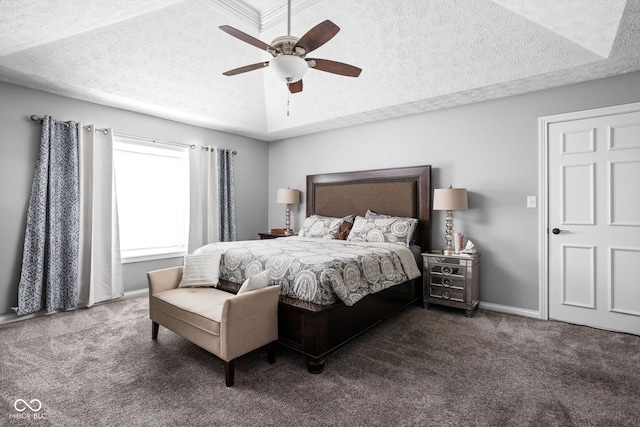 carpeted bedroom featuring ceiling fan, a raised ceiling, and a textured ceiling