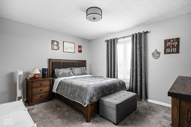 bedroom with a textured ceiling and dark colored carpet