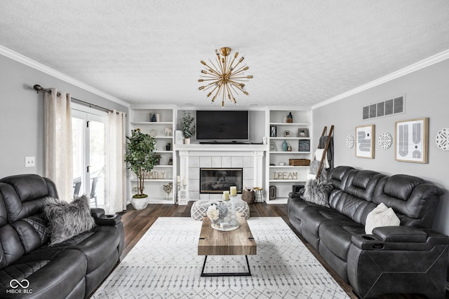 living room with a textured ceiling, dark hardwood / wood-style floors, crown molding, and a tiled fireplace