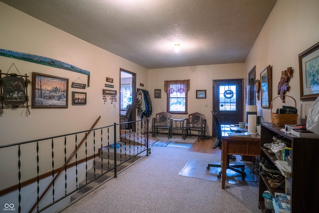 carpeted home office featuring a textured ceiling