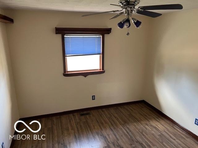 empty room with ceiling fan and dark hardwood / wood-style floors