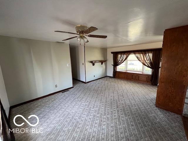 carpeted spare room with ceiling fan