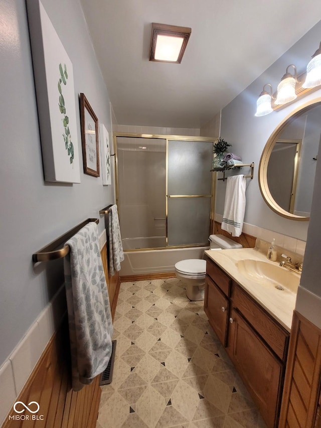 full bathroom with vanity, toilet, and bath / shower combo with glass door