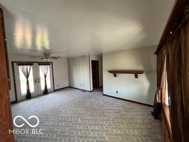 carpeted spare room with french doors and ceiling fan