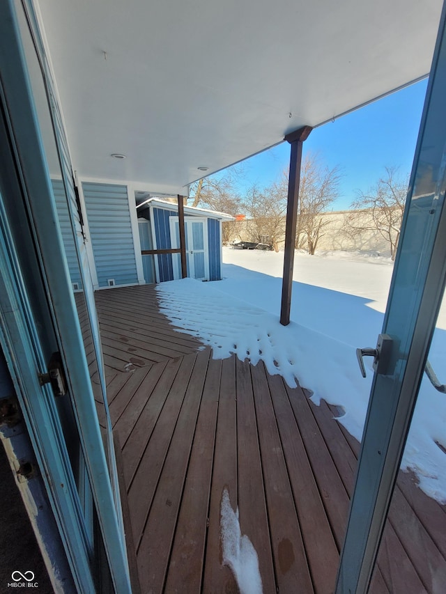 snow covered deck featuring a storage unit