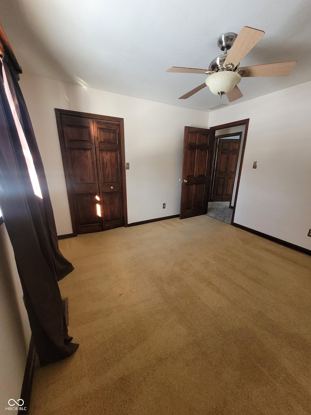 unfurnished bedroom featuring ceiling fan and light carpet