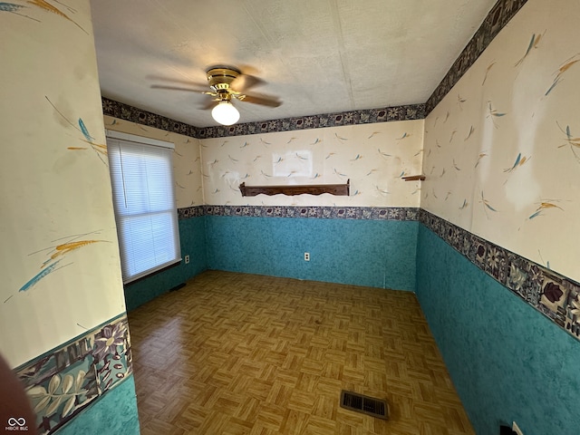 spare room with parquet flooring and ceiling fan