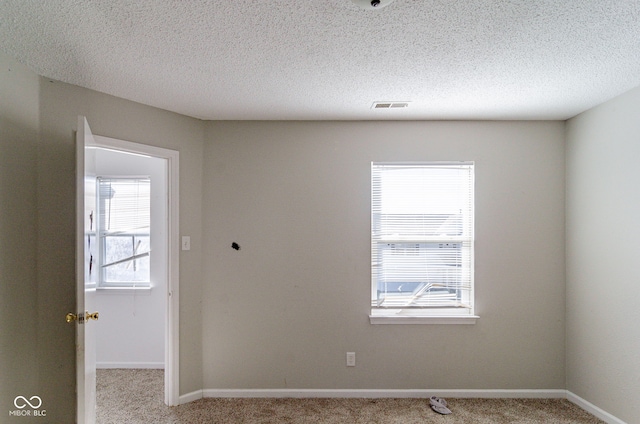 carpeted spare room with a textured ceiling