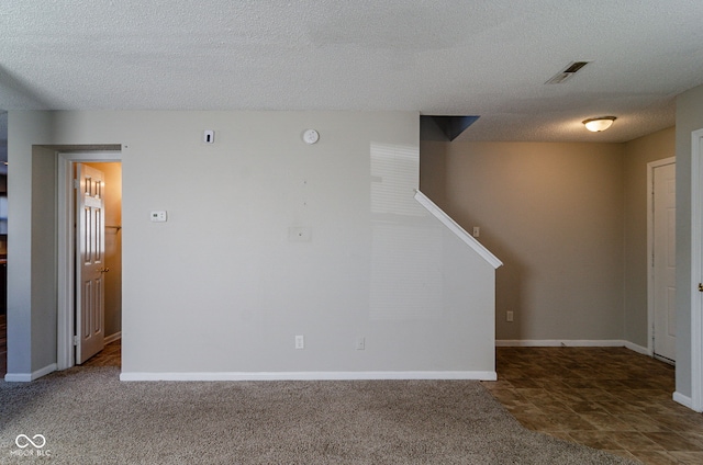 carpeted spare room with a textured ceiling