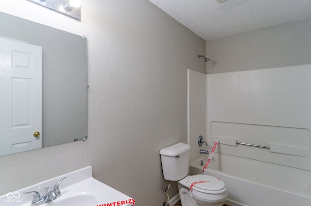 full bathroom featuring shower / bathing tub combination, toilet, sink, and a textured ceiling