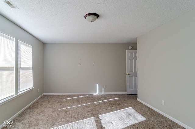 spare room with carpet floors and a textured ceiling