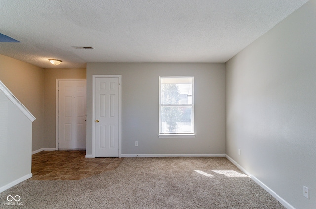 carpeted spare room featuring a textured ceiling