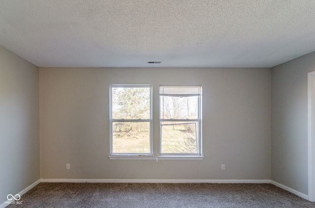 carpeted empty room with a textured ceiling