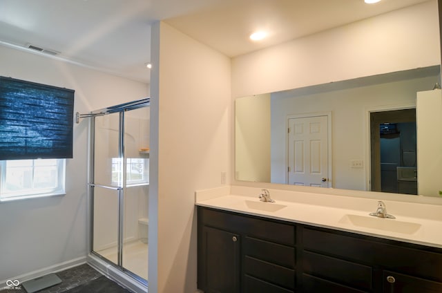 bathroom with vanity and a shower with shower door