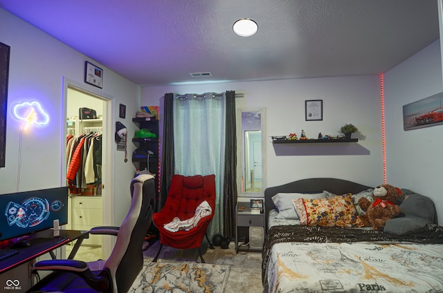 carpeted bedroom with a spacious closet, a closet, and a textured ceiling