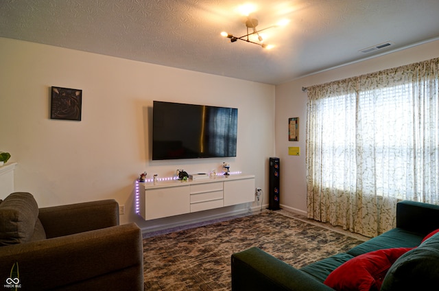 living room featuring a chandelier and a textured ceiling