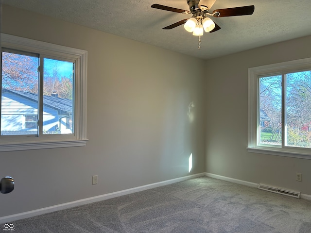 carpeted empty room featuring ceiling fan and a textured ceiling