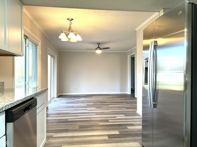 kitchen with crown molding, light stone countertops, white cabinetry, wood-type flooring, and stainless steel appliances