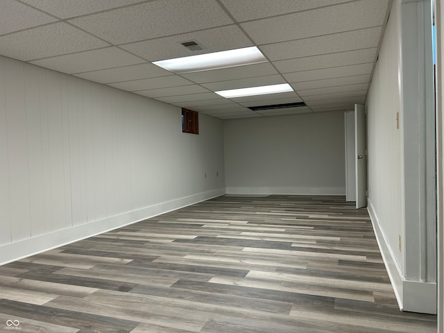 unfurnished room featuring hardwood / wood-style flooring and a drop ceiling