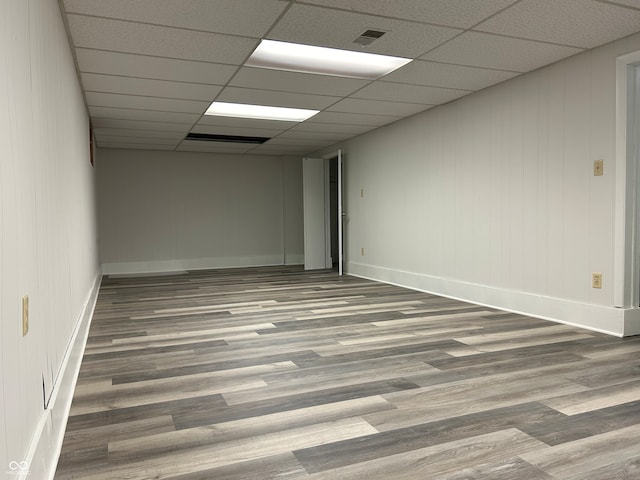 spare room featuring hardwood / wood-style floors and a drop ceiling