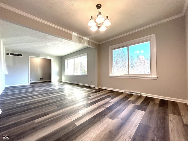 spare room featuring crown molding, dark hardwood / wood-style flooring, a textured ceiling, and an inviting chandelier