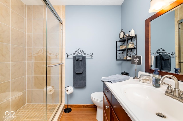 bathroom featuring toilet, walk in shower, vanity, and hardwood / wood-style flooring