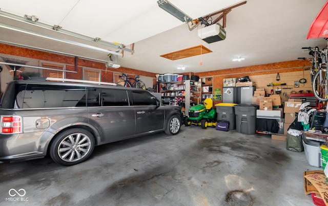 garage featuring a garage door opener and wooden walls