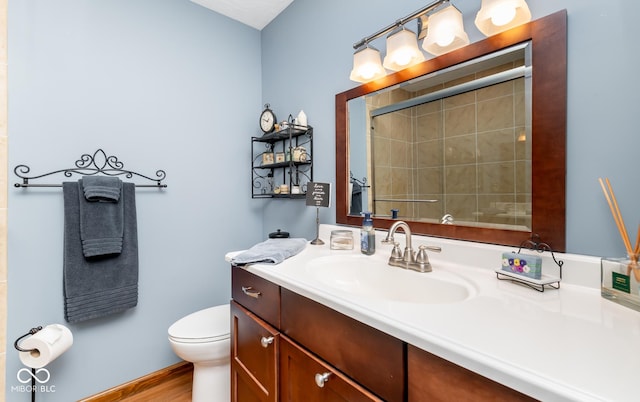 bathroom with vanity, a shower with shower door, and toilet