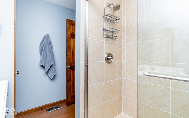 bathroom featuring a shower with door and wood-type flooring