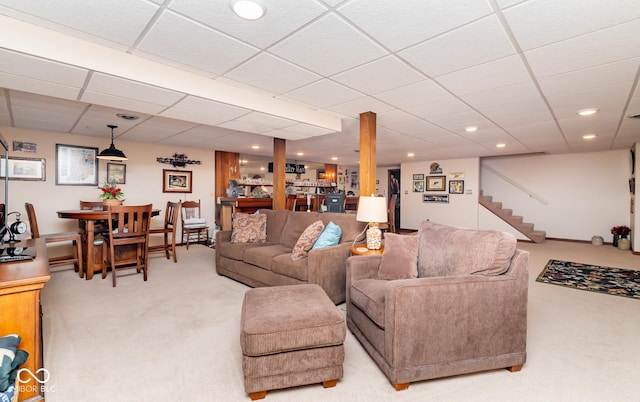 carpeted living room featuring a drop ceiling